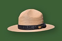 A straw ranger flat hat on a green background.