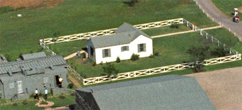 Aerial view of a small, white house.