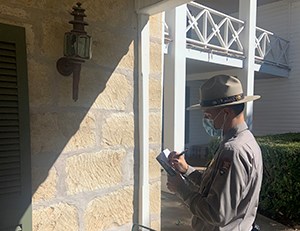 A park employee examines a light fixture on the porch at the Texas White House