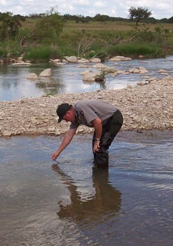 A park ranger conducts tests of the Pedernales River