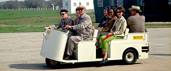 President and Lady Bird Johnson show guests the LBJ Ranch in a golf cart (1964)