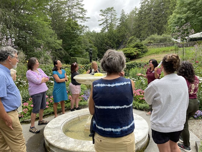 group of teachers gather in formal gardens