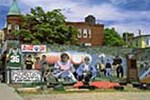 A colorful mural covers the side of a building on a city block.