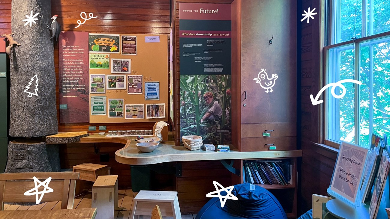 kids corner of visitor center with bulletin board full of nature images, exhibit on stewardship, digital white doodles surround image