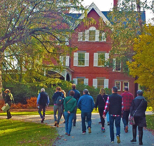 Ranger leads a group of visitors toward the Mansion in the Fall light
