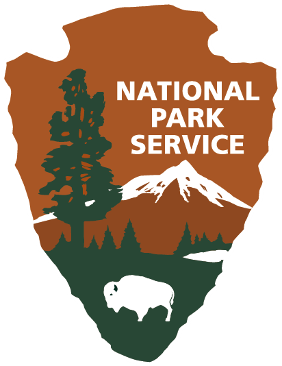 The National Park Service Arrowhead in brown, with green trees, and white mountains, bison, and text.