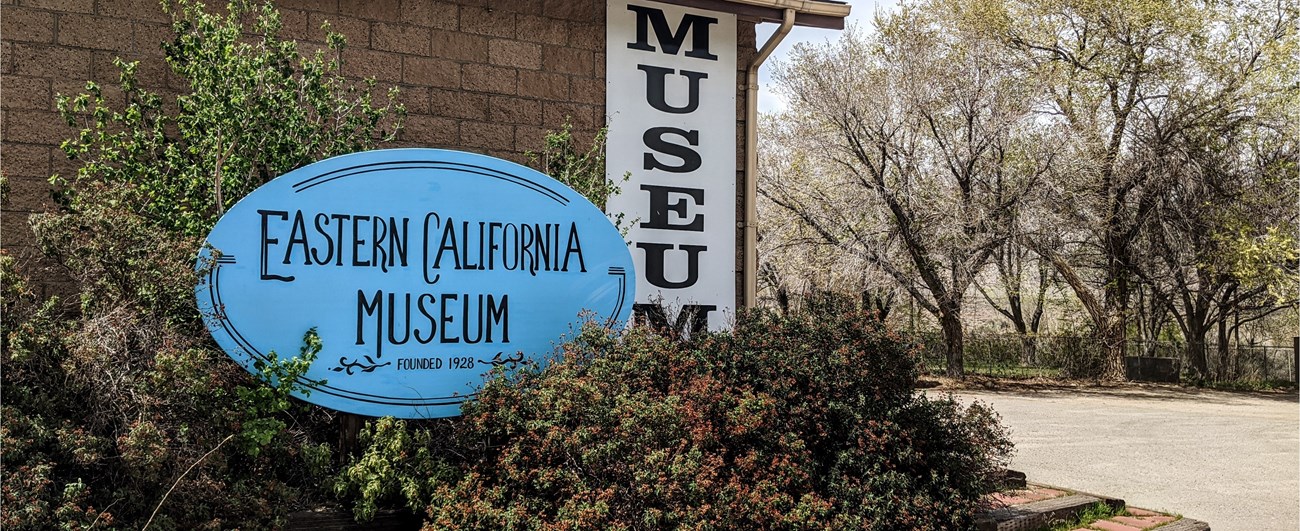 Eastern California Museum Sign outside building with bushes
