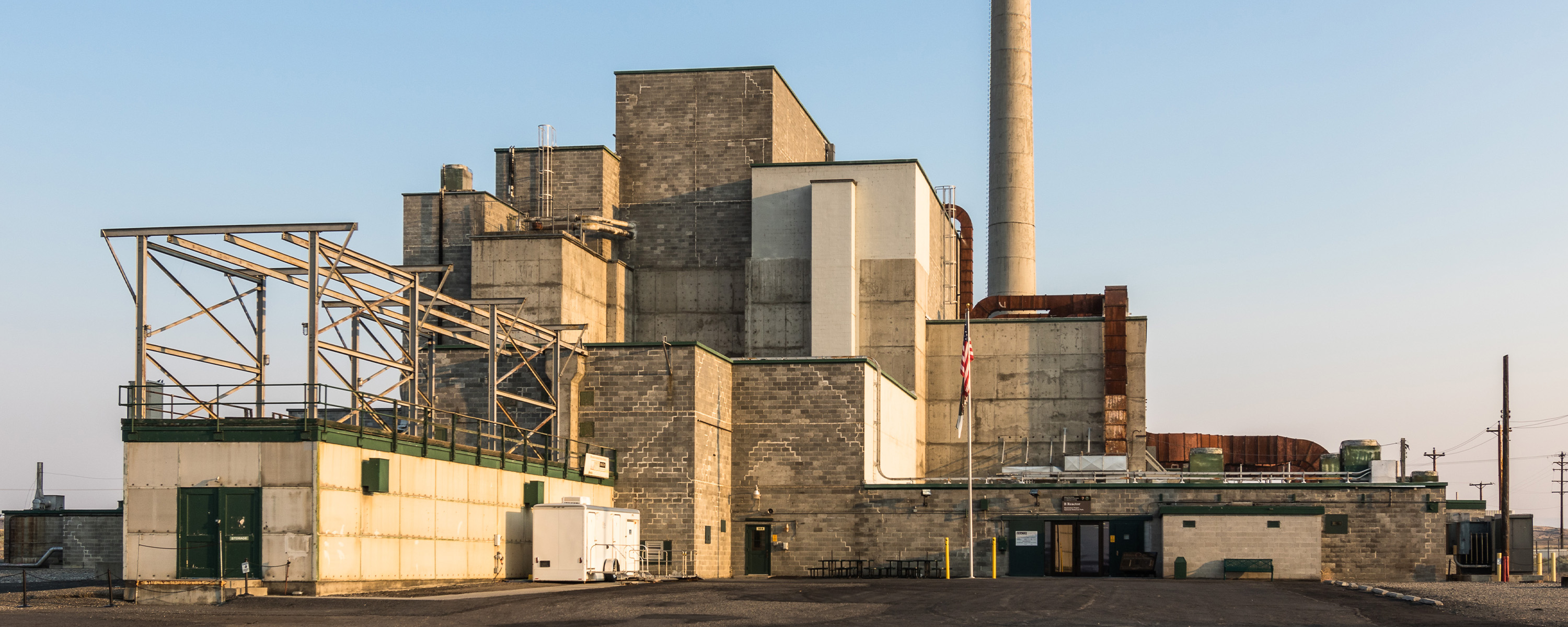 A large reactor building on a flat plain at sunset.