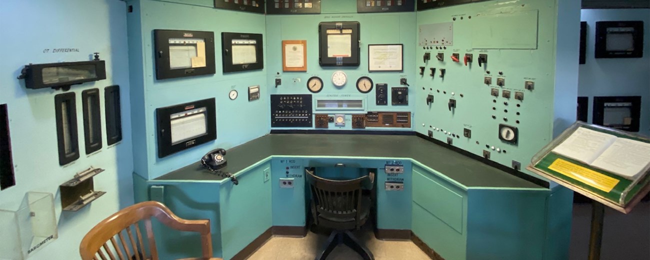 A green office desk with dials and knobs along the walls.