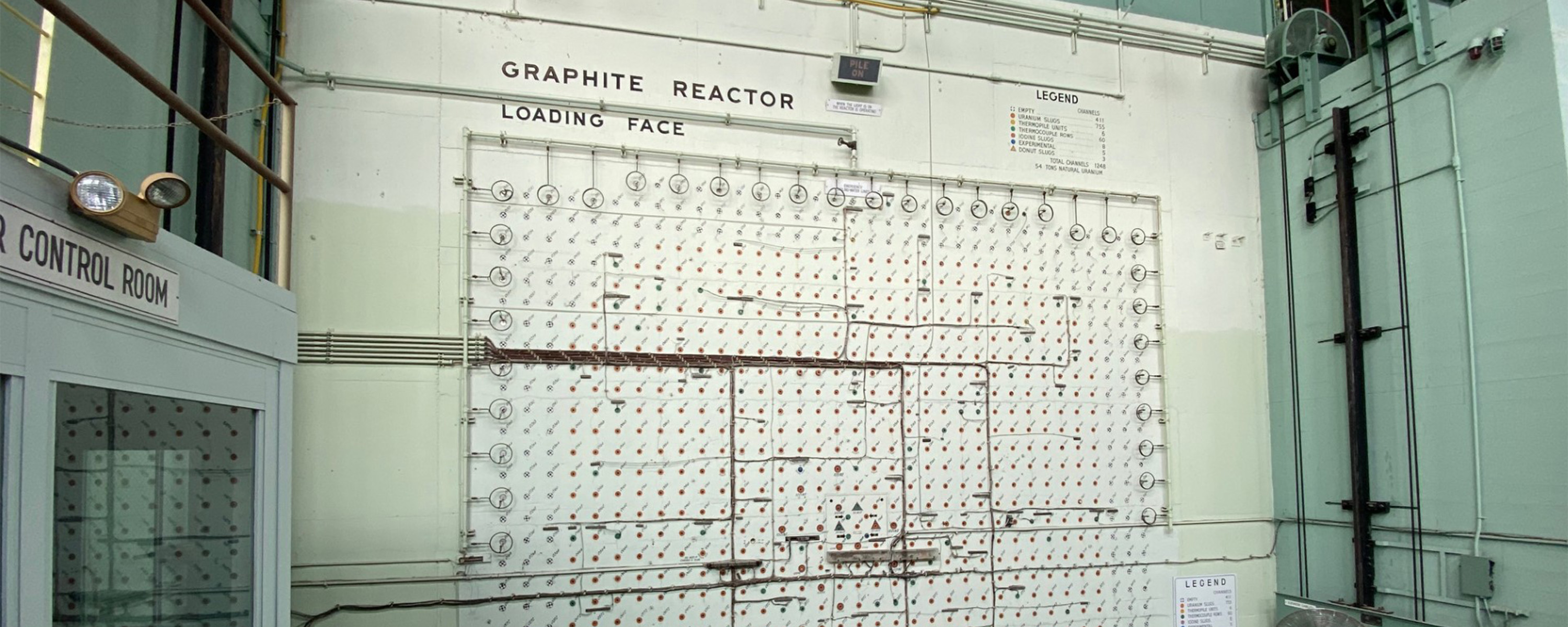 A color photo of a large green and off-white reactor face with the words Graphite Reactor Loading Face at the top of the face.