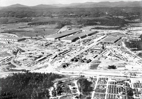 A black and white aerial view of an industrial complex.