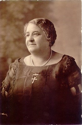 black and white portrait photograph of an African American woman wearing a cross brooch.