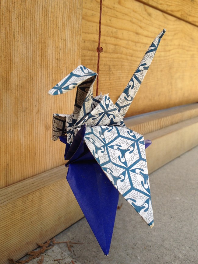 Origami crane made of blue, gray and white paper