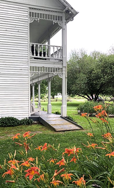 Ramp leads onto porch of historic two-story house