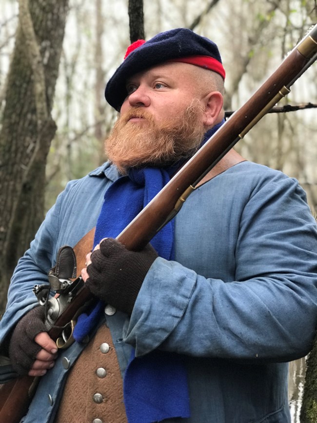 Highland Loyalists with blue hat blue jacket trees behind