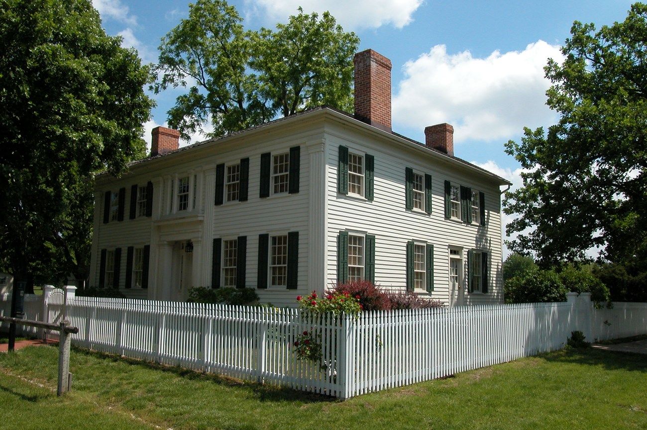 A large white two story historic house.
