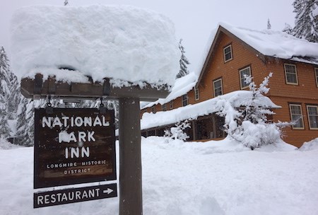 Snow-covered sign reading "National Park Inn" in front of a building.