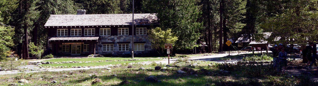 A wood and stone building surrounded by evergreen trees.