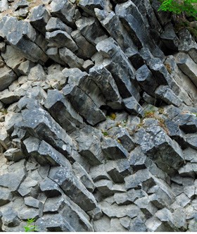An outcrop of grey column-shaped rocks.