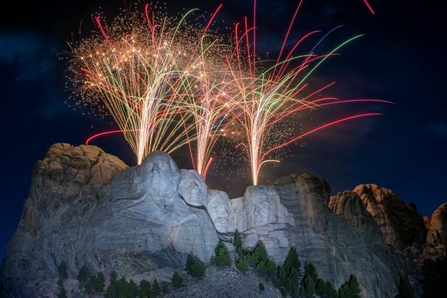Fireworks display at night over the faces of presidents at Mount Rushmore.