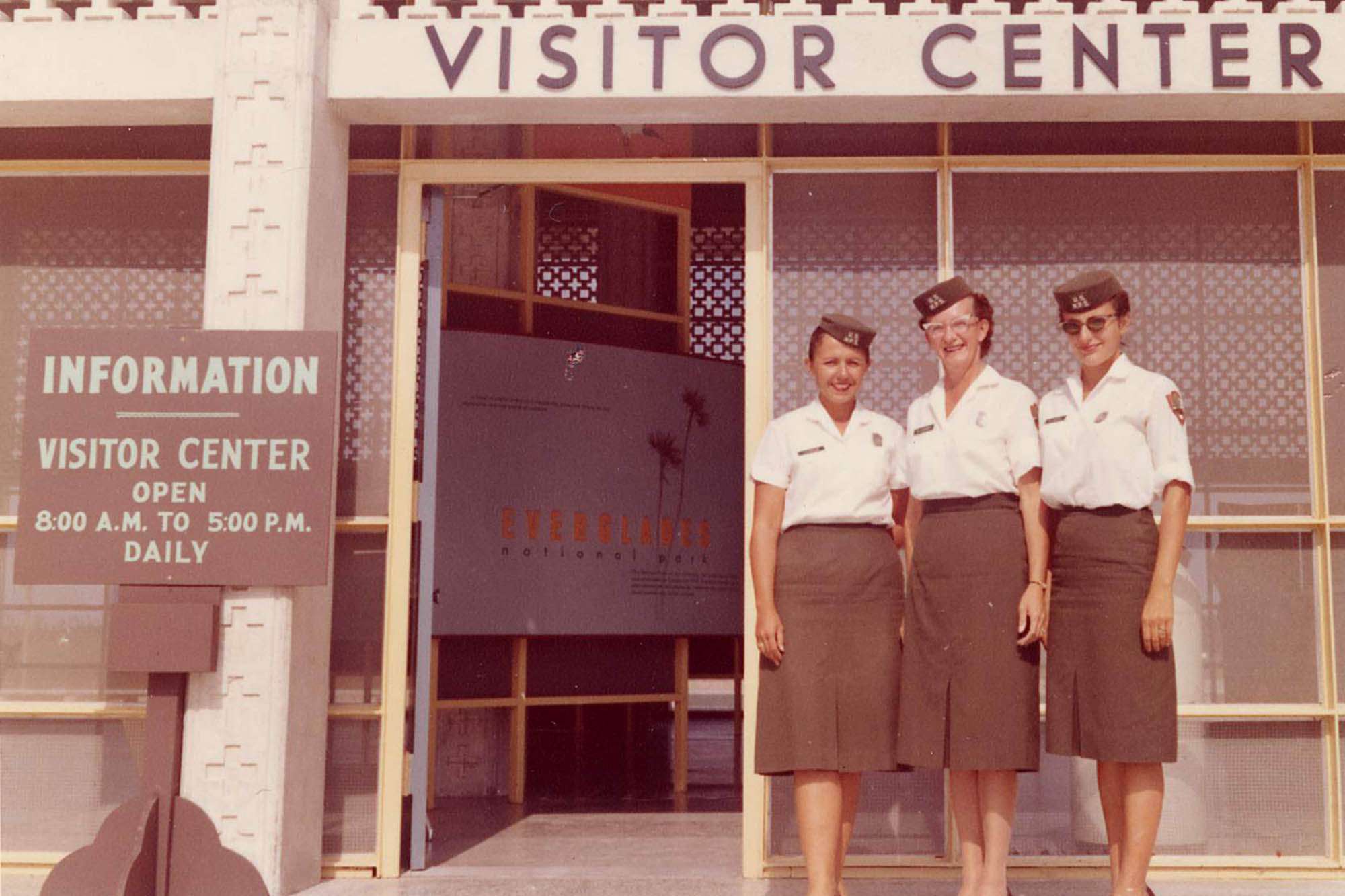 Three NPS female employees standing in front of Everglades visitor center