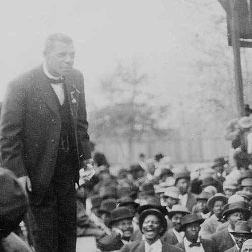 Booker T. Washington standing on a stage before large crowd in Lakeland