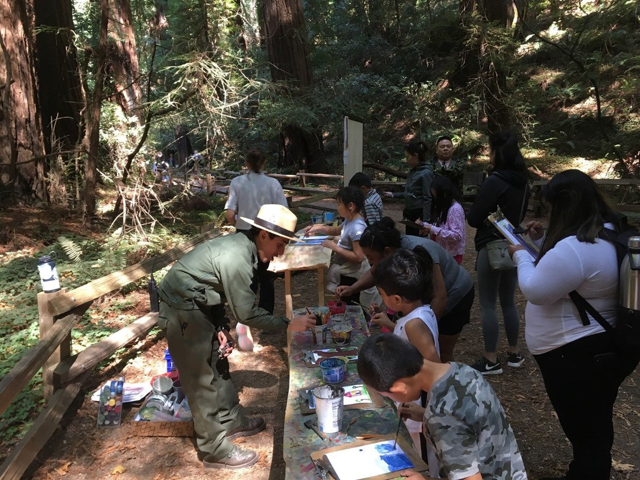 Park ranger engages with visitors at an Art in the Park event.