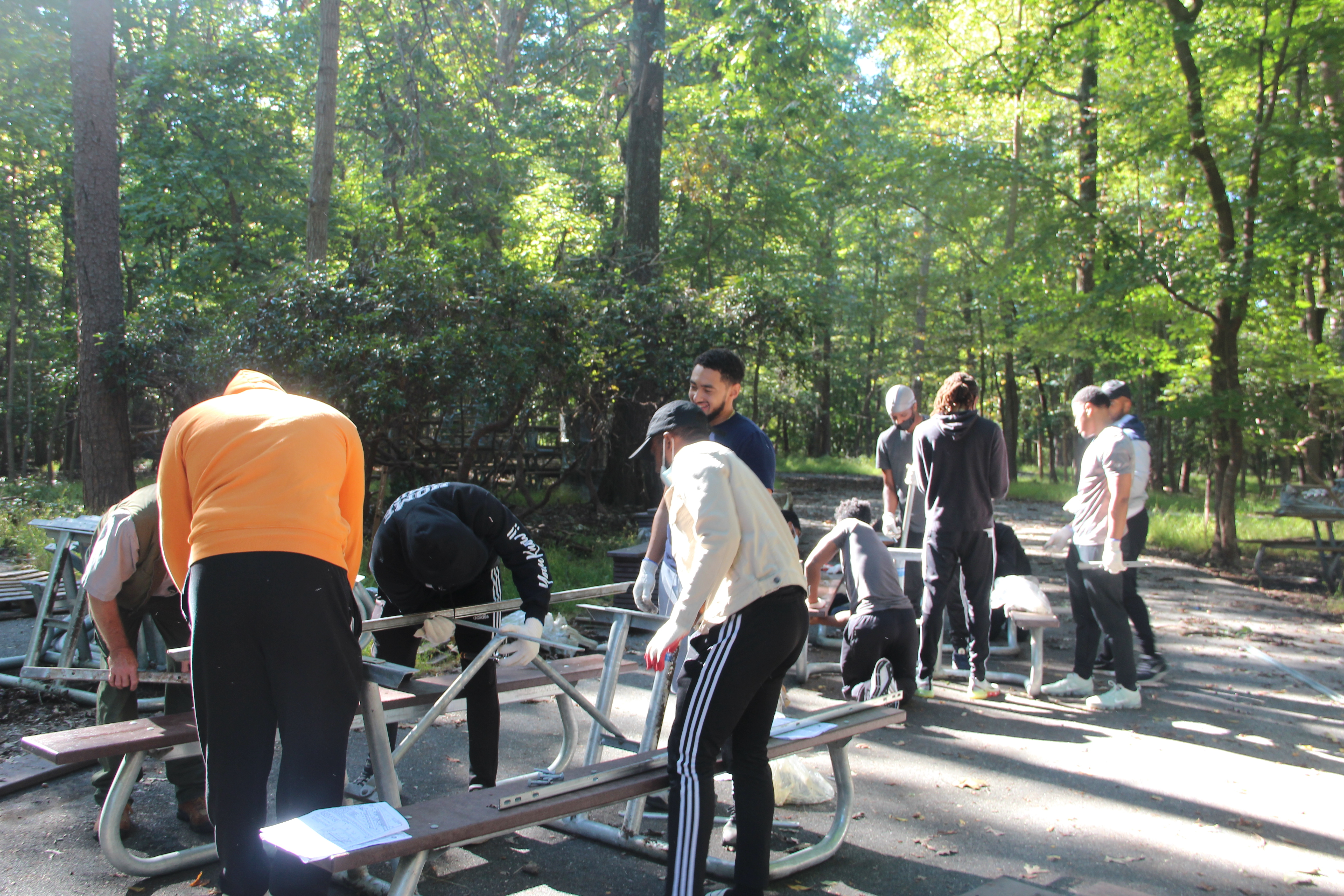A group of people assembling picnic tables.