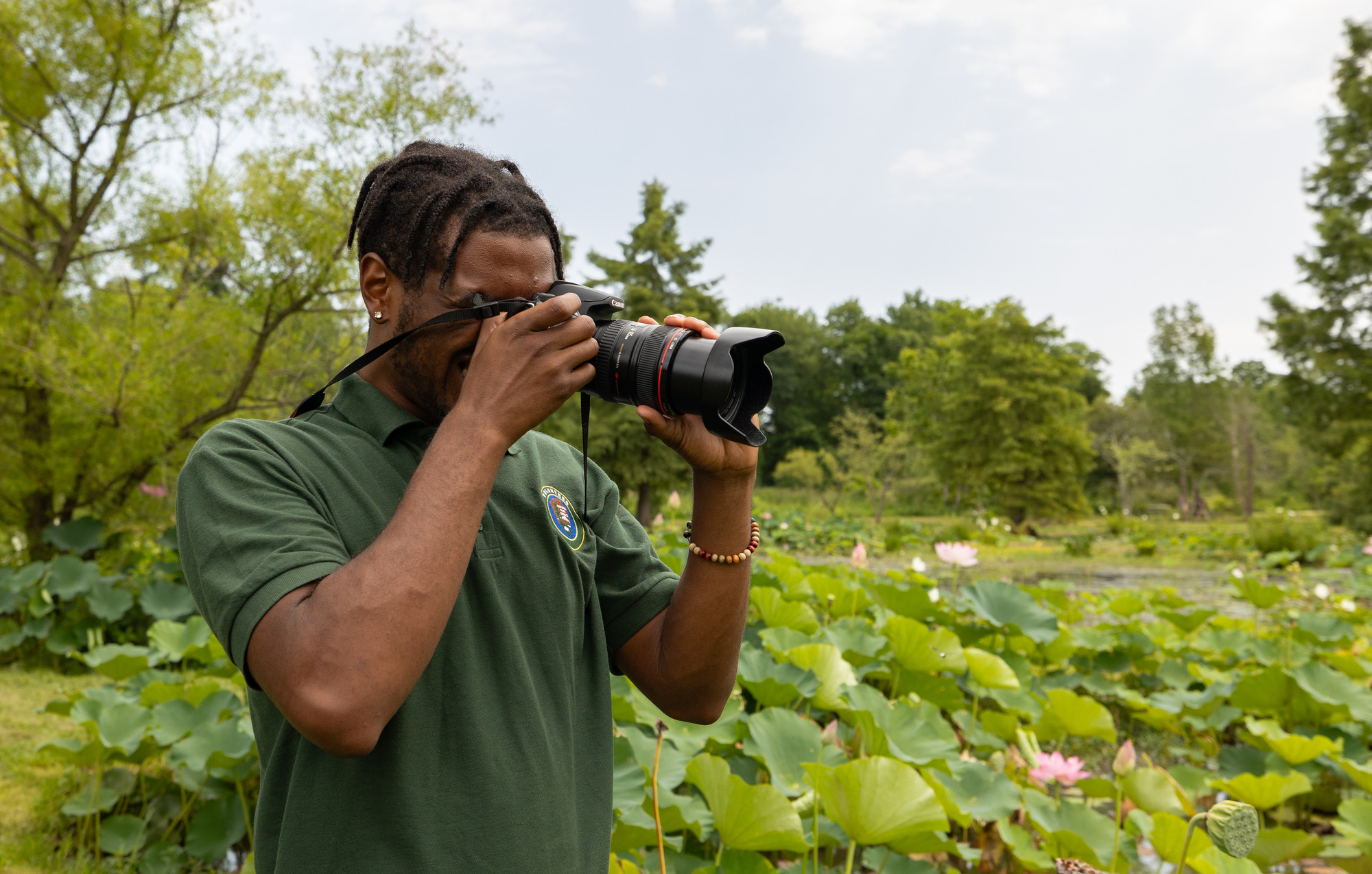 A man takes a photograph surrounded by lotuses