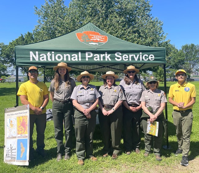 Volunteers and Park Rangers working an event tent