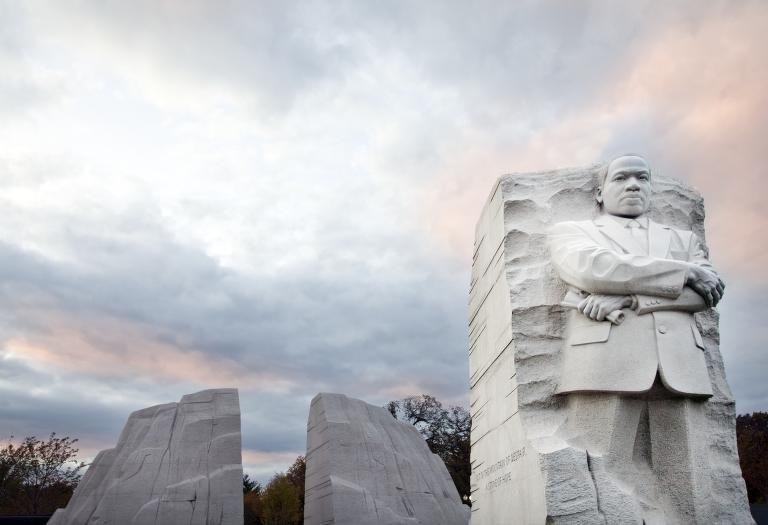 Relief Carving of Rev. Dr. Martin Luther King JR with his arms crossed the Mountain of despair carved from marble behind him.