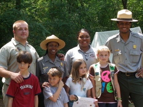 a group of park rangers, volunteers, and new junior rangers pose for the camera
