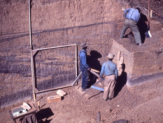 Emerald Mound Excavation. Three men in work clothes standing next to archaeological dig at Emerald Mound