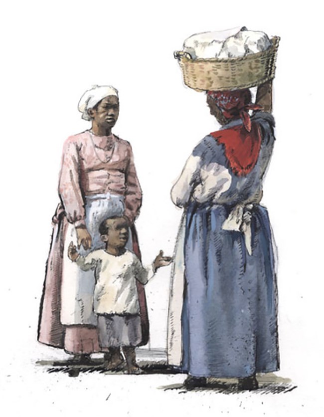 Two dark-skinned women in long dresses and aprons, one with a small boy and the other carrying a clothes basket on her head.