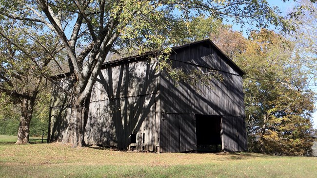 A large wood barn with doors on either end.