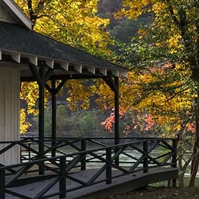 cabin porch overlooking river with fall colors