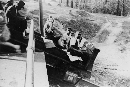 historic photo of people in a haulage car being lowered down a steep track