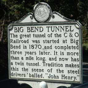 A white metal historical marker sign with black letters marking the Big Bend Tunnel