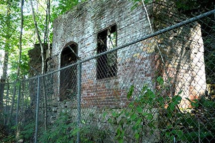 ruins of an old stone building with a fence around it