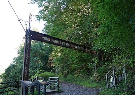metal beam with safety message over trail with stairs