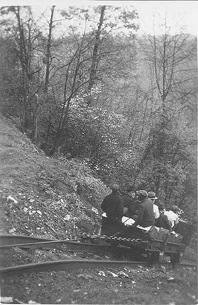 historic photo of people riding a cart down a track into a steep gorge