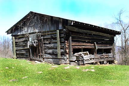 old wood barn on grassy hill