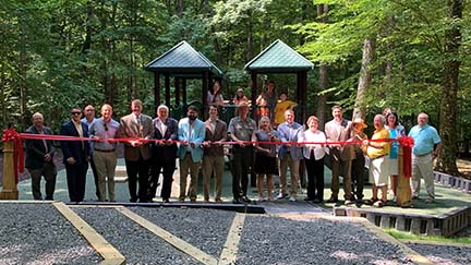people cutting a ribbon in front of a playground