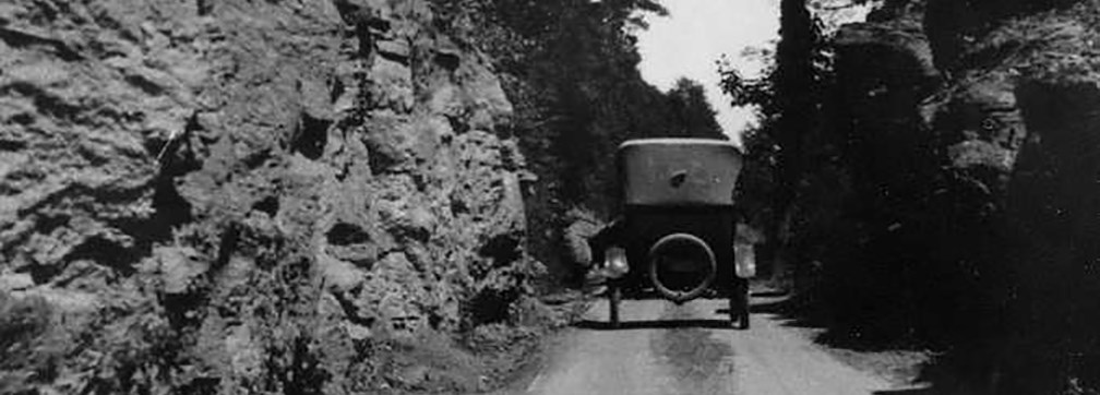 historic photo of old car on dirt road