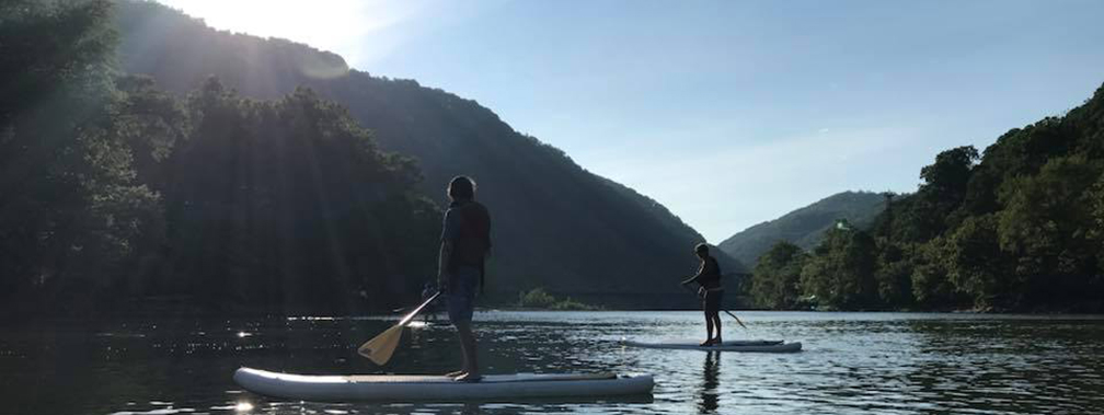 2 people on stand up paddle boarders on the river