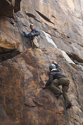climbers scaling a cliff