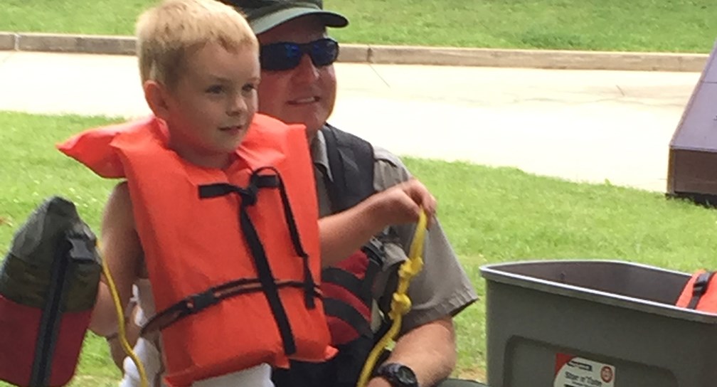 ranger teaching child about life jackets