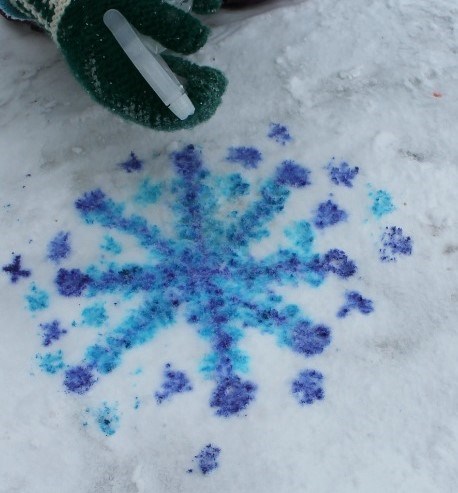 a blue snow flake painted on white snow