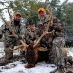 Three veterans with elk enjoying hunting on public lands.