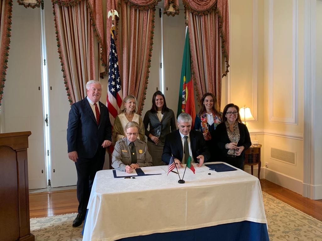 Officials sign papers at a desk
